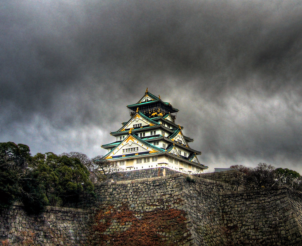 Osaka Castle with stone walls and moat against a blue sky